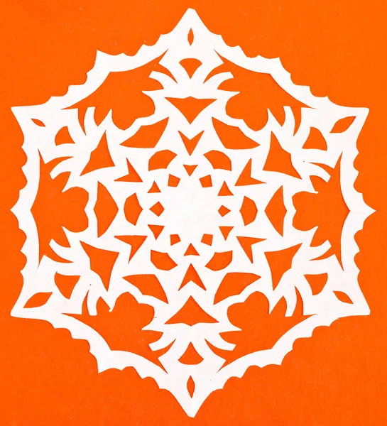 White snowflake on orange paper — Stock Photo, Image