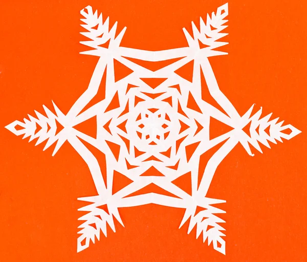 White snowflake on orange paper — Stock Photo, Image