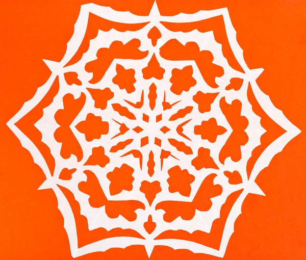 Witte sneeuwvlok op oranje papier — Stockfoto