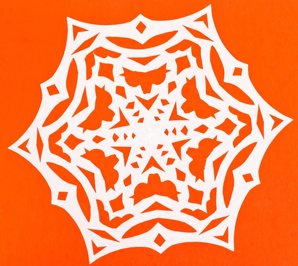 Weiße Schneeflocke auf orangefarbenem Papier — Stockfoto