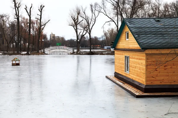 Bevroren meer met bridge en houten huis — Stockfoto