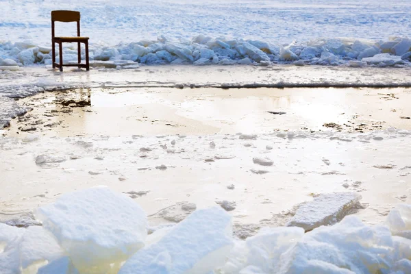 Silla de hielo cerca del agujero de hielo en el lago congelado — Foto de Stock