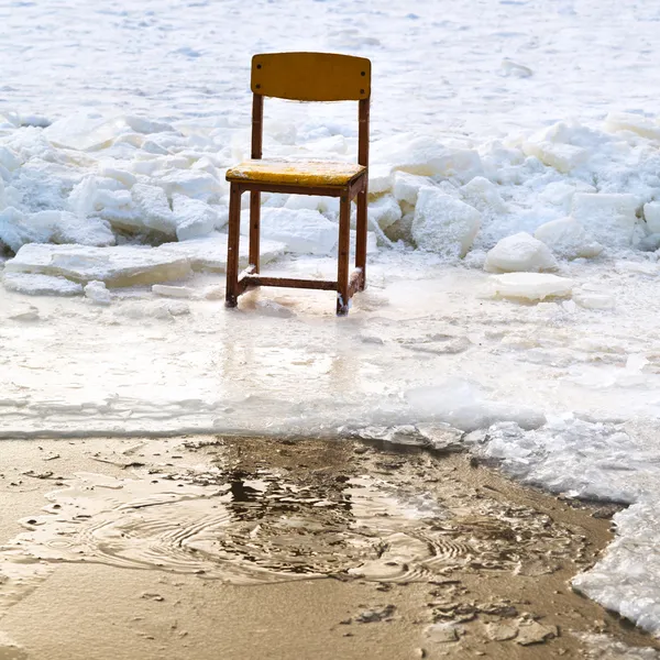 Icebound krzesło na krawędzi przerębli w zamarzniętym jeziorze — Zdjęcie stockowe