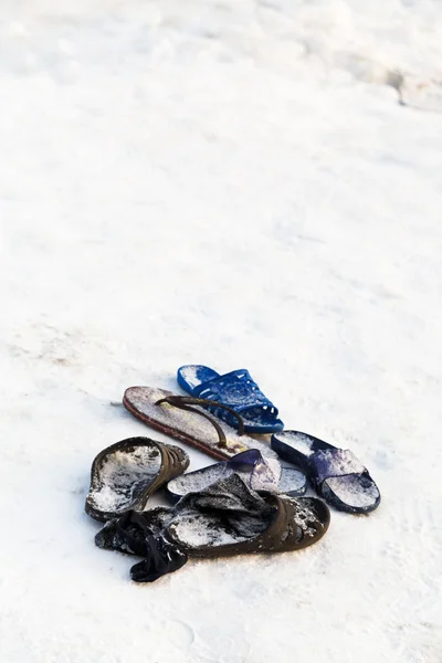 Bevroren slippers in de buurt van sneeuw rand van ijsgat — Stockfoto