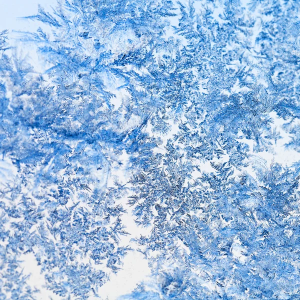 Snowflakes and frost pattern on glass close up — Stock Photo, Image