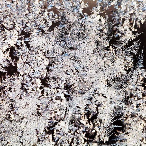 Snowflakes and frost pattern on glass close up — Stock Photo, Image