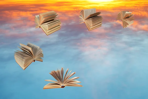 Books fly over sunset clouds — Stock Photo, Image