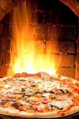 Pizza fırında jambon, mantar ve yangın alevleri