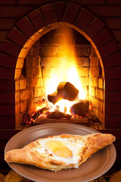 Adzharian khachapuri with egg and fire in stove — Stock Photo, Image