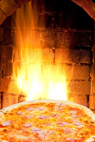 Pizza with prosciutto cotto and fire flame in oven — Stock Photo, Image