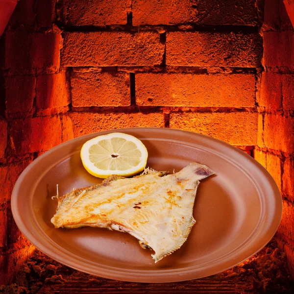Lenguado frito pescado en plato y ladrillos calientes del horno —  Fotos de Stock