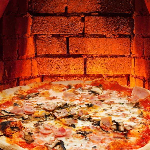 Pizza with ham, mushroom and brick wall of oven — Stock Photo, Image