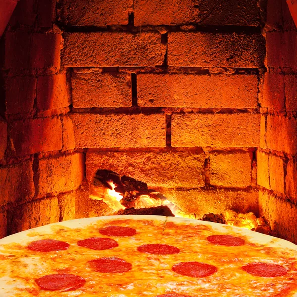 Pizza with salami and hot brick wall of oven — Stock Photo, Image