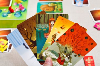 Dixit game cards in hand clipart