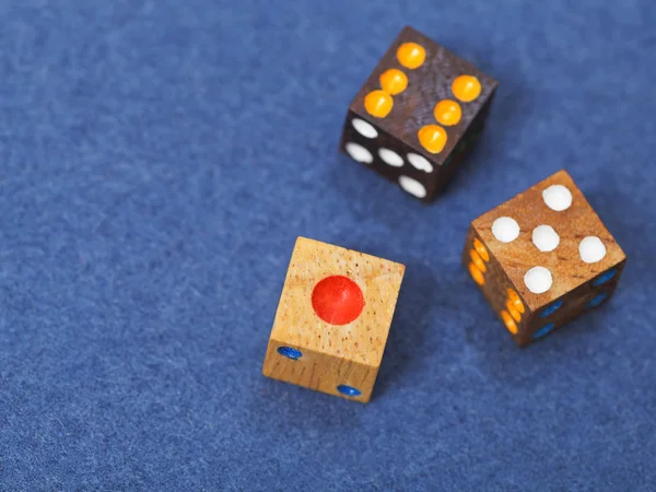 Três dados de jogo de madeira em pano azul — Fotografia de Stock