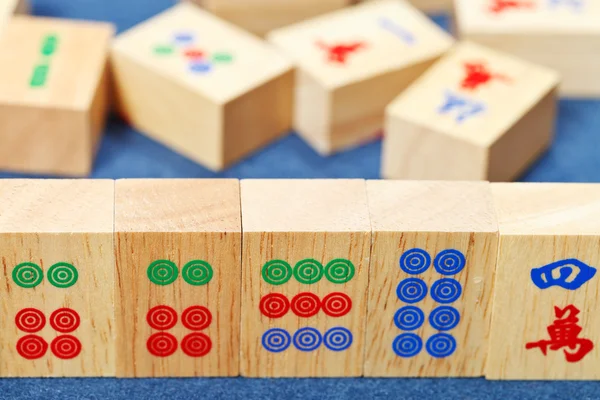 Telhas de madeira closeup no jogo mahjong em pano azul — Fotografia de Stock