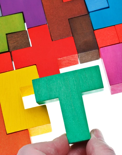 Placing T-shaped piece in wooden puzzle — Stock Photo, Image