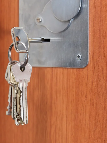 Monte de chaves de casa no buraco da fechadura da porta — Fotografia de Stock