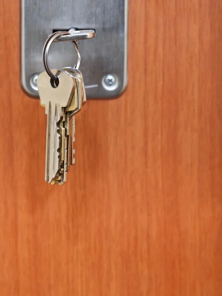 Bunch of steel keys in keyhole of door — Stock Photo, Image