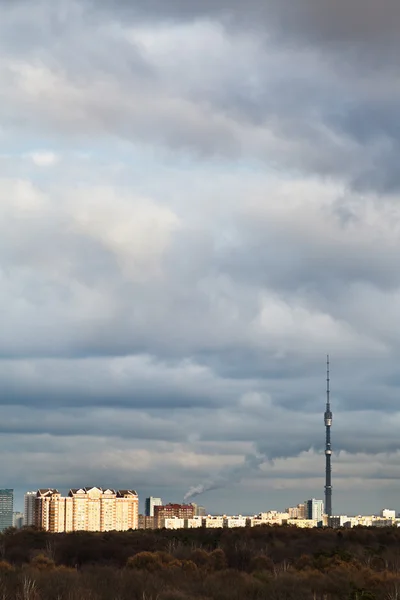 Evening clouds over houses and TV tower — Stock Photo, Image