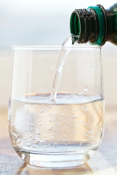 Quellwasser in Glas gegossen — Stockfoto