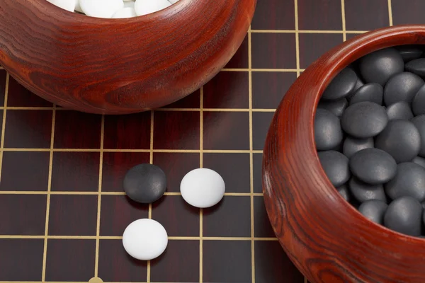 Black and white go game stones and wooden bowls — Stock Photo, Image