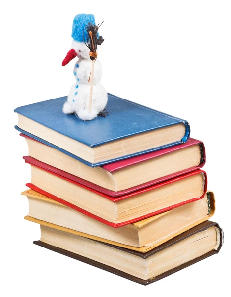 Toy snowman stands on old books — Stock Photo, Image