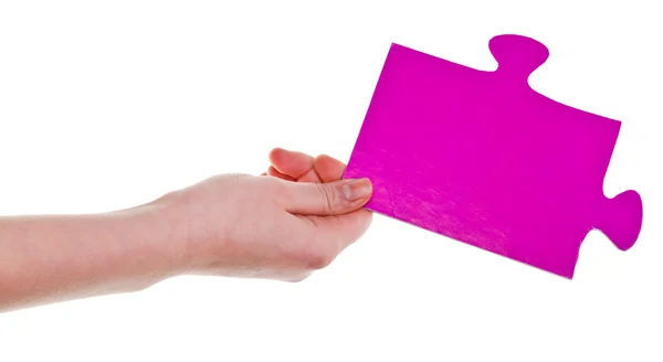 大きなピンクの紙のパズルのピースを持っている女性の手 — ストック写真