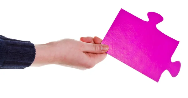Γυναικείο χέρι που κρατά το μεγάλο ροζ χάρτινο παζλ κομμάτι — Φωτογραφία Αρχείου