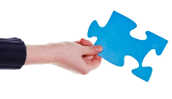 Female hand holding big blue paper puzzle piece — Stock Photo, Image