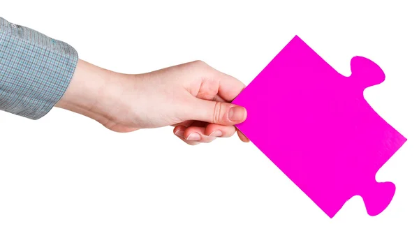 Kvinnlig hand som håller stora rosa papper pusselbit — Stockfoto