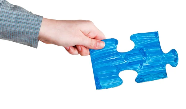 Female hand with painted blue puzzle piece — Stock Photo, Image