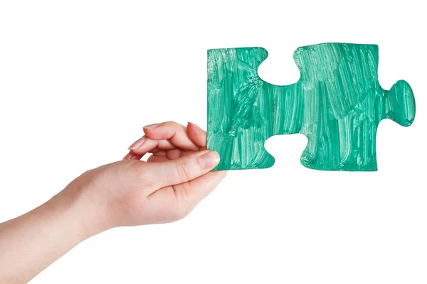 Ręka z kawałek układanki zielony malowany — Zdjęcie stockowe