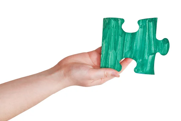 Ręka z kawałek układanki zielony malowany — Zdjęcie stockowe