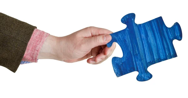 Мужская рука с раскрашенной голубой головоломкой — стоковое фото