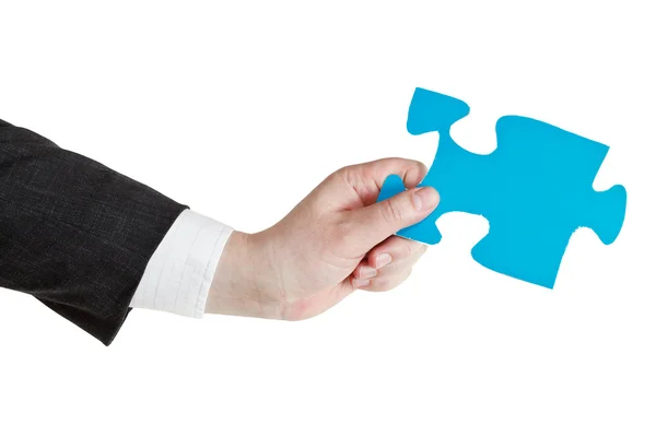 Male hand holding big blue paper puzzle piece — Stock Photo, Image