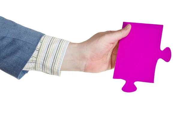 Mano masculina sosteniendo gran pieza de rompecabezas de papel rosa —  Fotos de Stock