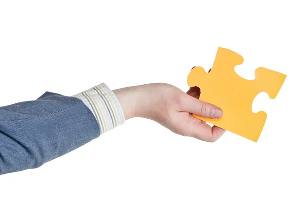 Male hand holding big yellow paper puzzle piece — Stock Photo, Image