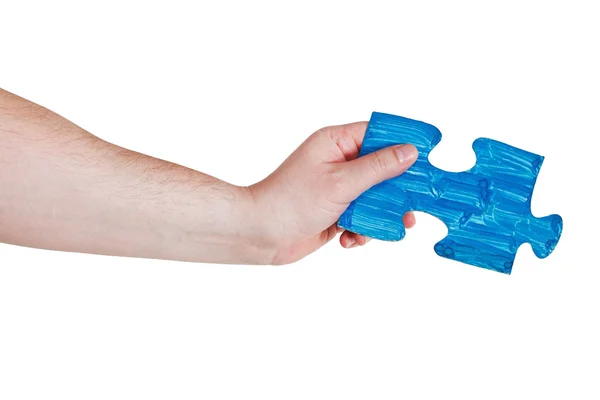 Mano maschile con dipinto pezzo puzzle blu — Foto Stock