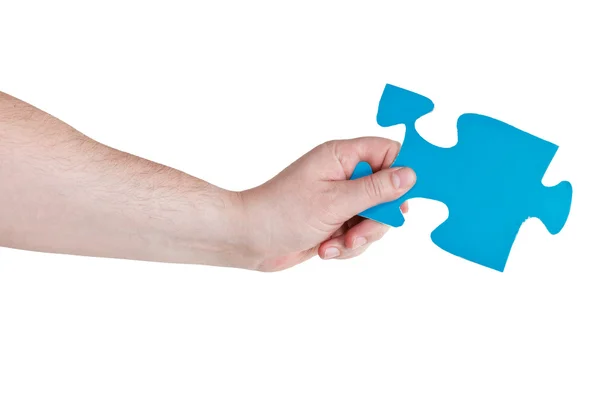 Mano maschile tenendo grande pezzo di puzzle di carta blu — Foto Stock