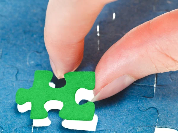 De laatste groene stukje van de puzzel passen — Stockfoto