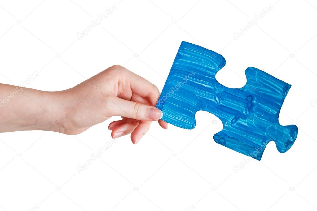 female hand with painted blue puzzle piece
