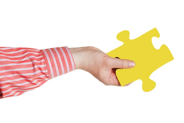 Αρσενικό χέρι με κίτρινο παζλ κομμάτι — Φωτογραφία Αρχείου