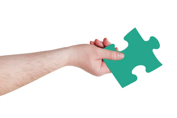 Мужская рука с зеленым кусочком головоломки — стоковое фото