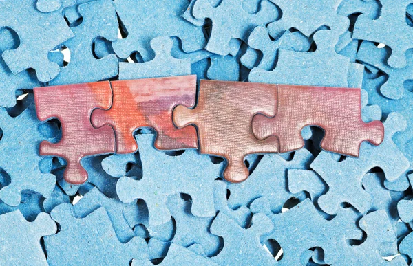 Paar verbonden stukken op stapel gescheiden puzzels — Stockfoto