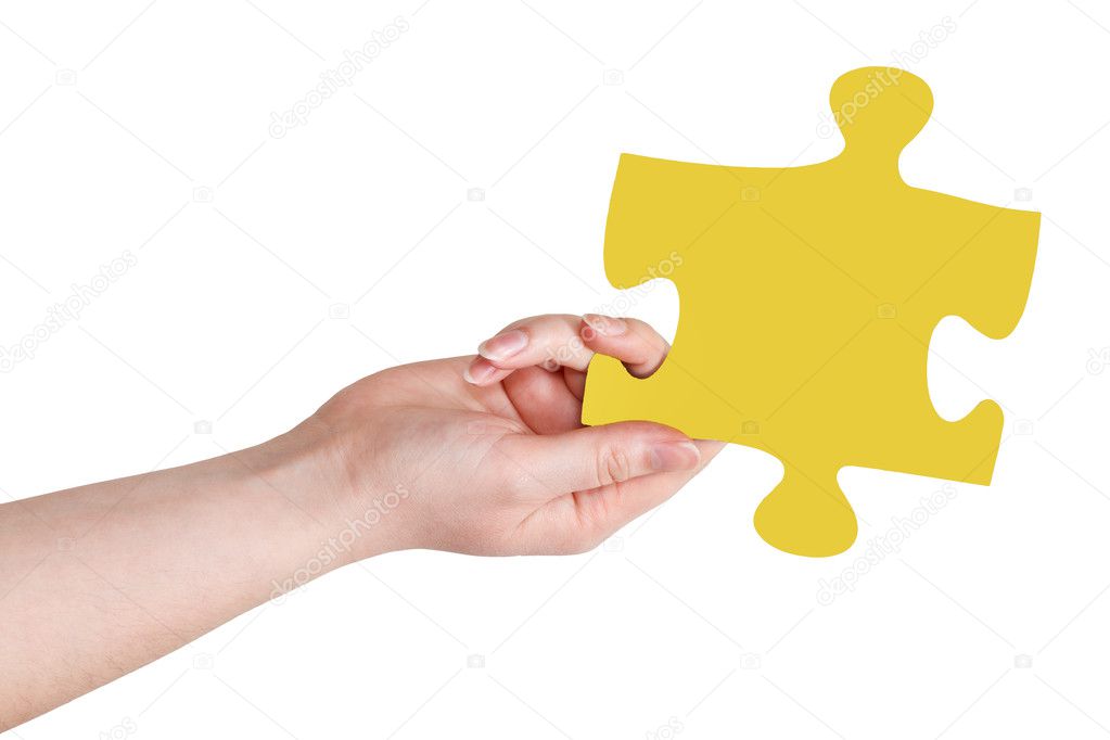female hand with yellow puzzle piece