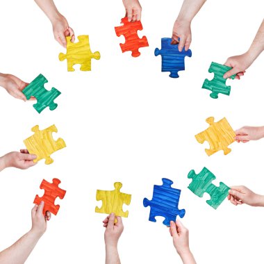 insanlar ellerinde daire boyalı puzzle parçaları