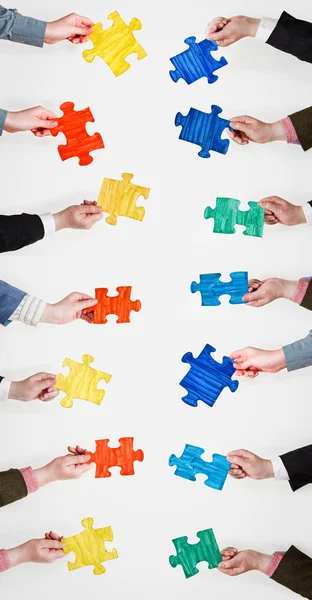 Set painted puzzle pieces in people hands — Stock Photo, Image