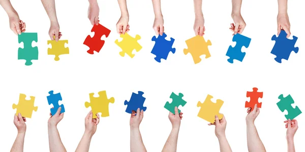 Zestaw różnych puzzli w ludzie ręce — Zdjęcie stockowe