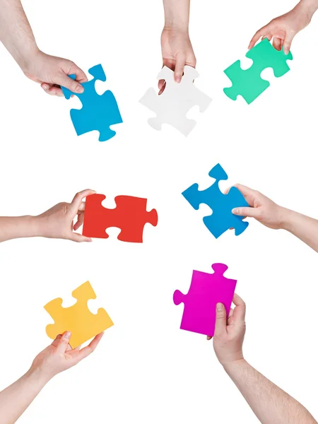 Persone mani cerchio con diversi pezzi di puzzle — Foto Stock